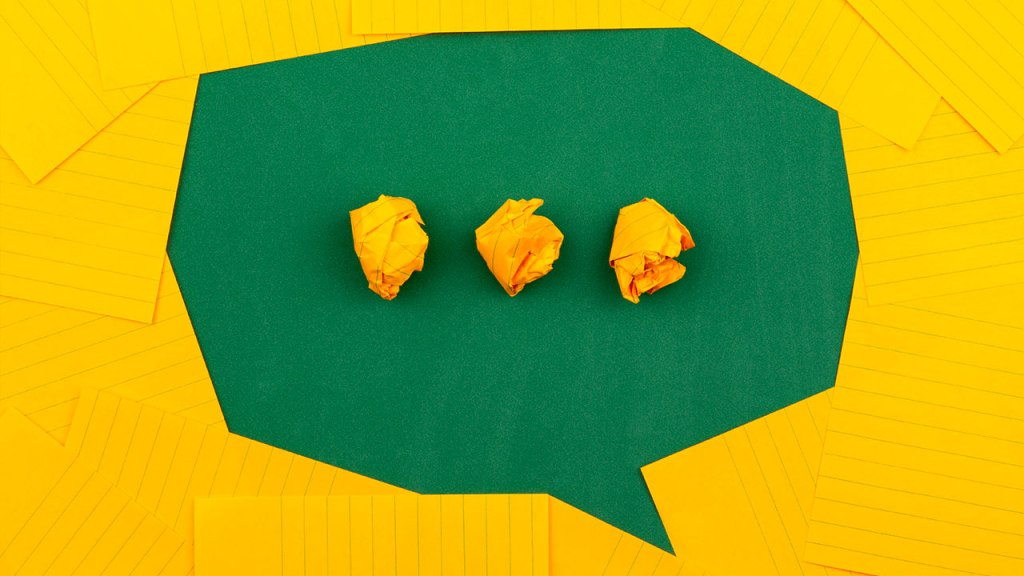 Immagine di copertina. Post-it gialli su un tavolo verde creano la sagoma di un fumetto. Al centro tre post-it appallottolati come puntini di sospensione.